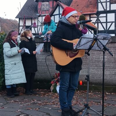 Bild vergrern: Pfarrer Andres Synofzik spielte Gitarre und brachte Vorweihnachtsstimmung auf den Kirchplatz.